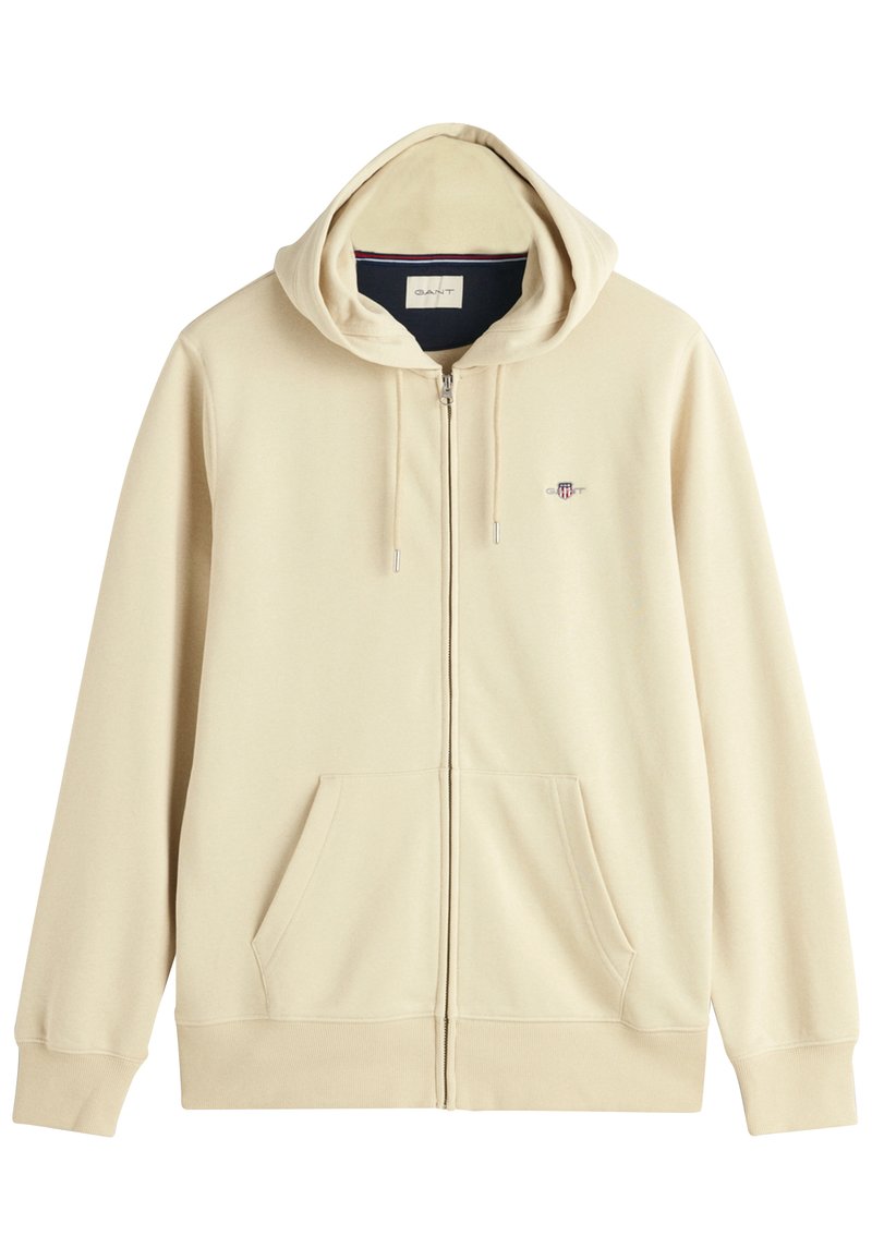 Beige Kapuzenjacke mit Reißverschluss, großem Kapuze, Fronttaschen und gesticktem Logo. Hergestellt aus weichem Material mit langen Ärmeln und gerippten Bündchen.