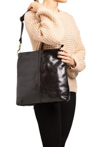 Borsa a tracolla nera in pelle con una texture liscia, forma rettangolare e dettagli cuciti. Presenta una tracolla removibile e accessori metallici lucidi.