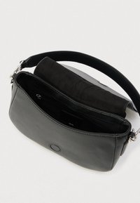 Čierna kožená kabelka s hladkým vonkajším povrchom, vybavená čiernou semišovou chlopňou a strieborným zapínaním. Vo vnútri je vrecko so zipsom.