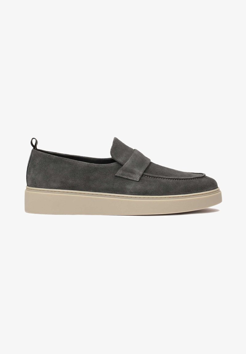 Mocasines de ante gris con una tira ancha en la parte superior, suela de goma beige y una lengüeta en el talón para facilitar el calzado. Textura suave.
