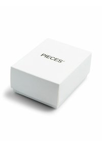 Boîte rectangulaire blanche aux bords légèrement arrondis, avec le mot « PIECES » imprimé en noir sur la surface supérieure.