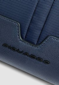 Borsa blu navy realizzata in materiale canvas testurizzato, con dettagli in pelle liscia e logo impressa sul davanti.
