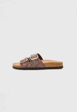 Brown slip-on sandals with two adjustable straps, textured upper, cork footbed, and rubber sole. Suitable for casual wear.