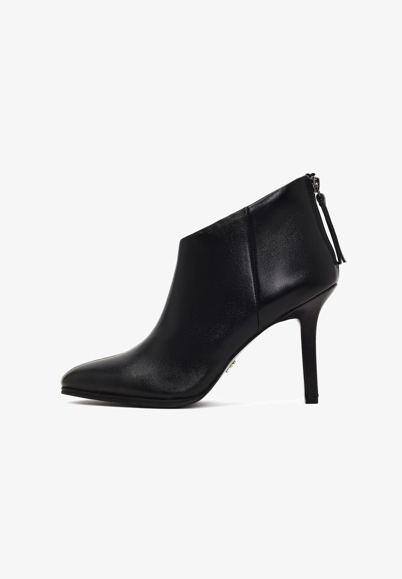 Bota de tobillo de cuero negro con punta afilada, alto tacón de aguja y cierre con cremallera lateral. Textura suave sin patrones ni acentos.