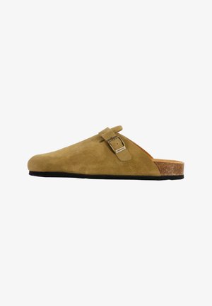 Zoccolo in camoscio color beige con plantare in sughero, caratterizzato da un'unica fibbia metallica regolabile e una suola in gomma nera texturizzata.