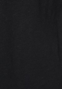 Textura pevné černé tkaniny s jemnými vzory tkaní a drobnými povrchovými nepravidelnostmi.