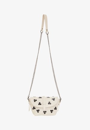 Krém színű bőr keresztpántos táska fekete hatszögletű szegecsekkel. Lepelzáróval és lánc pánttal rendelkezik. Kompakt téglalap alakú.