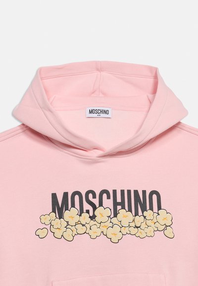 Ανοιχτό ροζ φούτερ με μαύρο κείμενο "MOSCHINO" που καλύπτεται μερικώς από ένα γραφικό ποπ κορν μπροστά και μια μικρή ετικέτα "MOSCHINO KID" στο εσωτερικό.