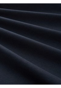 Mørk marineblå stof med en glat tekstur, der viser subtile draperinger og folder, som illustrerer dets bløde og fleksible materiale egenskaber.