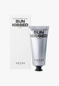 Tube z półtrwałym połyskiem do włosów w kolorze srebrnym, opatrzony etykietą „SUN KISSED BLOND”, obok białego pudełka z czarnym napisem i nazwą marki „S H Y N E”.
