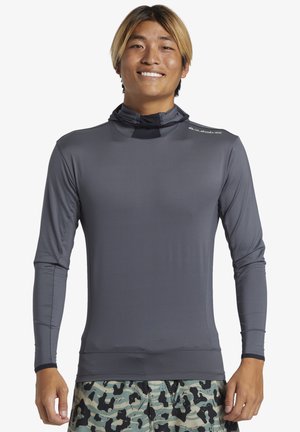 Lange mouw, lichte rashguard in donkergrijs, met een aansluitend ontwerp en hoge hals. Gladde textuur met een logo op de schouder.