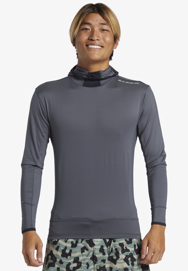 Långärmad, lätt rash guard i mörkgrått, med en åtsittande design och hög krage. Slät textur med en logotyp på axeln.