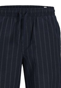 Pantalons rayés marine en tissu léger avec une taille élastique et un cordon de serrage. Présentent des fines rayures verticales contrastées.