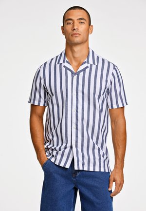 Camisa de manga corta con botones en blanco con rayas verticales en azul marino, con cuello campestre y un ajuste relajado. Hecha de tela ligera.