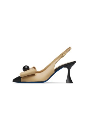 Beige slingback high heel shoe with black pointed toe, sculpted black heel, oversized bow, and round black decorative element on top.