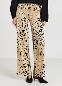 Beige Samt-Hose mit weitem Bein und schwarzem Leopardenmuster. Verfügt über eine hohe Taille und Fronttaschen, kombiniert mit spitzen schwarzen High Heels.