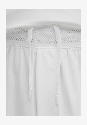 Balti sportiniai šortai su tekstūruota medžiaga, elastinga juosta su akių paneliu ir raišteliais. Lengvas ir kvėpuojantis dizainas.
