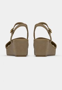 Μπεζ πλατφόρμες με ομαλή υφή, διαθέτουν ρυθμιζόμενους λουράκια αστραγάλου και χρυσό αγκράφα για διακόσμηση. Λαστιχένιες σόλες για καλύτερη πρόσφυση.