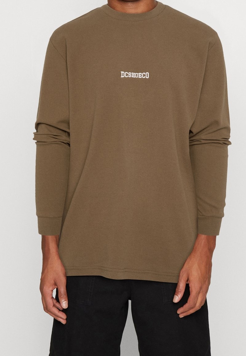 Pitkähihainen, oliivinvihreä collegepaita pehmeästä kankaasta, jossa rinnassa pieni valkoinen "DCSHOECO"-logo ja resorireunaiset hihansuut.