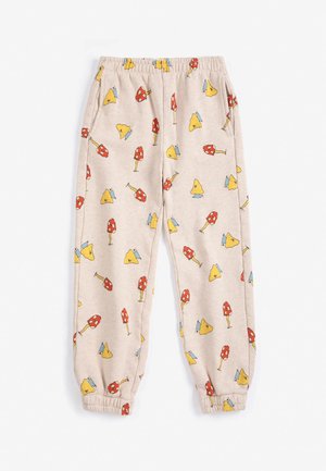 Pantalon de jogging beige à taille élastique avec poignets élastiques et un motif de champignons rouges et jaunes sur l’ensemble.
