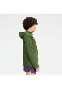 Grüne wasserdichte Jacke mit Kapuze, langen Ärmeln und einer Kängurutasche vorne. Der Stoff ist glatt und hat eine matte Oberfläche.