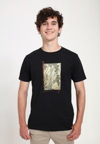 Sort t-shirt med et trykt design af bambus i dæmpede farver med røde tekstakcenter. Bomuldsstof med en klassisk pasform.