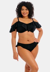 Set di bikini nero con top a spalle scoperte a ruches e slip coordinati con dettagli a ruches. Materiale morbido e elastico.