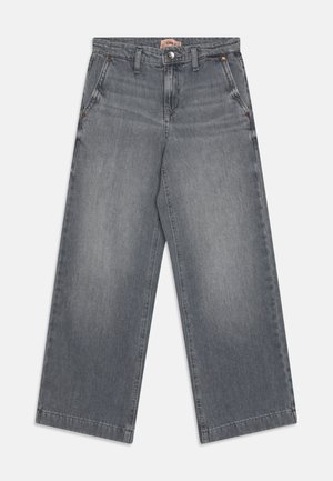 Jeans de pierna ancha gris, hechos de mezclilla, con cierre de botón y cremallera, que cuentan con dos bolsillos laterales y una pequeña etiqueta de la marca en la cinturilla.