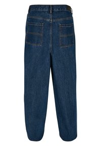 Pantaloni in denim blu scuro, vestibilità ampia, con due tasche posteriori e cuciture in vista. La vita include un elastico nero per maggiore comfort.
