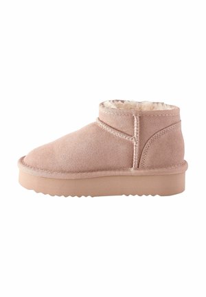 Bottine en suède rose clair avec doublure en fourrure douce et semelle beige texturée, vue de profil sur un fond blanc.