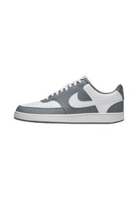 Graue und weiße Lederturnschuhe im Low-Top-Design, mit einem strukturierten grauen Obermaterial, weißer Zwischensohle und prominentem Swoosh-Logo.