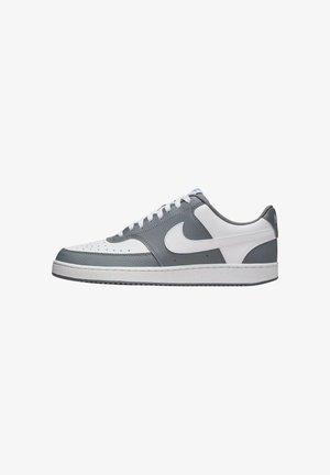 Sneaker in pelle grigia e bianca con design low-top, caratterizzate da una tomaia grigia texturizzata, suola intermedia bianca e un logo swoosh prominente.
