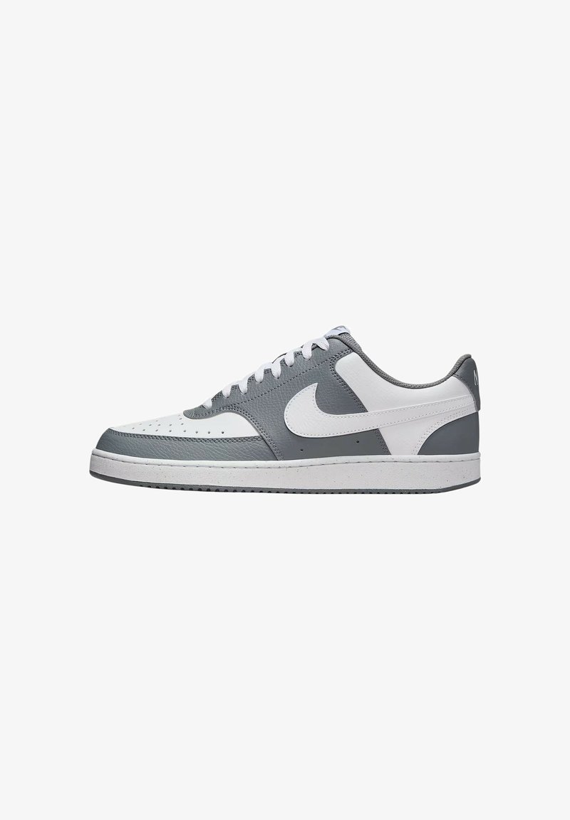 Sneaker in pelle grigia e bianca con design low-top, caratterizzate da una tomaia grigia texturizzata, suola intermedia bianca e un logo swoosh prominente.