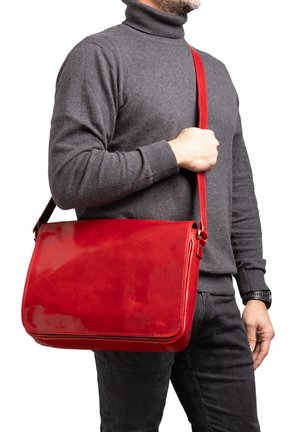 Borsa a tracolla in pelle rossa con finitura lucida, forma rettangolare e tracolla regolabile, indossata attraverso il corpo.