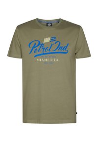T-shirt en coton vert olive à manches courtes, col rond, avec un design textuel bleu et blanc qui indique "Petrol Ind Miami U.S.A."