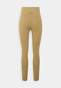 Leggings bege com uma cintura alta, apresentando linhas diagonais texturizadas e um acabamento suave. Nome da marca "casall" embossado na cintura.