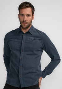 Navyblauwe button-up shirt van een zachte stof, met een borstzak en bruine knopen, lange mouwen en een kraag.