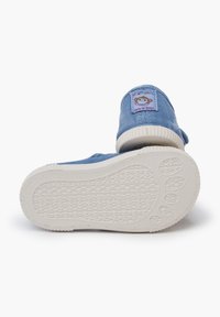 Modré plátěné slip-on boty s bílými gumovými podrážkami, zdobené hravou nášivkou opice na patě a strukturální podrážkou pro lepší přilnavost.