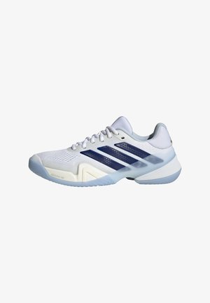 Chaussures de sport blanches avec dessus en mesh, trois bandes bleu marine, et contrefort texturé au talon. Elles présentent une semelle extérieure en caoutchouc bleu clair et une semelle intérieure rembourrée.