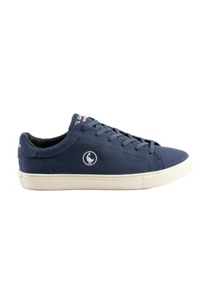 Zapatilla deportiva baja azul marino con suela de goma blanca, cierre de cordones en la parte delantera y un logo de pájaro blanco en el lateral.