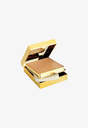 Gold Compactpuder-Case mit glattem, mattem bronzefarbenem Puder im Inneren. Enthält einen weißen Applikatorschwamm. Reflexives Innere.