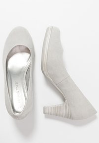 Grå mocka högklackade skor med rund tå och en strukturerad kontrasterande klack, med en silverfärgad innersula och en stilren design.