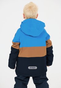 Färgglad jacka med blå, bruna och marinblå paneler. Huva, slät textur med logotyp på baksidan, designad för utomhusbruk.