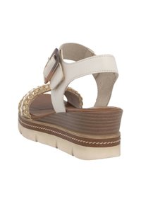 Białe sandały na koturnie z sztucznej skóry, z plecionym detalem, regulowanym paskiem i teksturowaną brązową podeszwą. Posiadają piętę złożoną i miękką podszewkę.