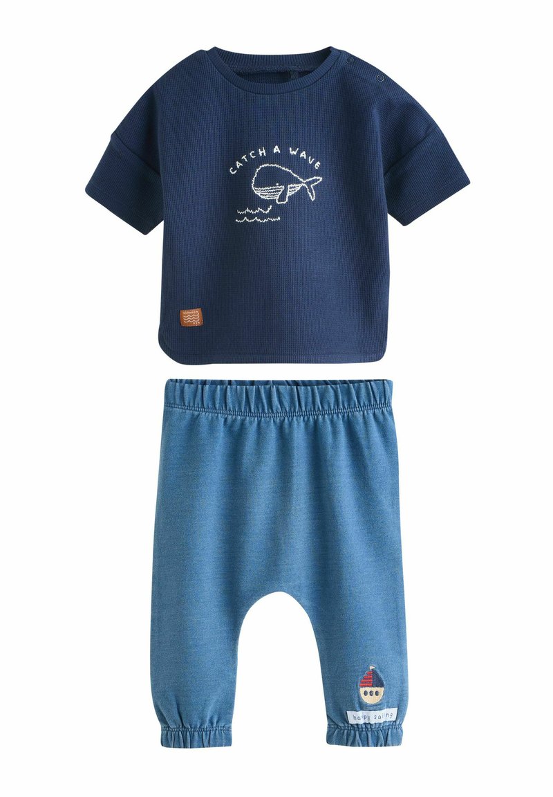 Chemise à manches courtes marine avec broderie de baleine "Attrape une vague" et pantalon bleu denim avec taille élastique et patch de voilier.