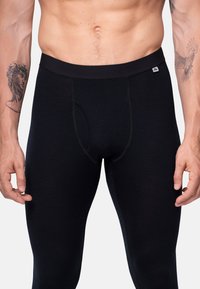 Sorte thermoleggings lavet af strækstof med en tætsiddende pasform. Har en blød elastisk talje og en forreste åbning.