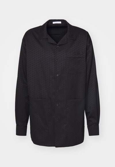 Schwarzes Hemd mit Knöpfen, einem subtilen strukturierten Muster, langen Ärmeln, mit eingeschnittenem Kragen und einer Brusttasche. Weicher Stoff und klassisches Design.