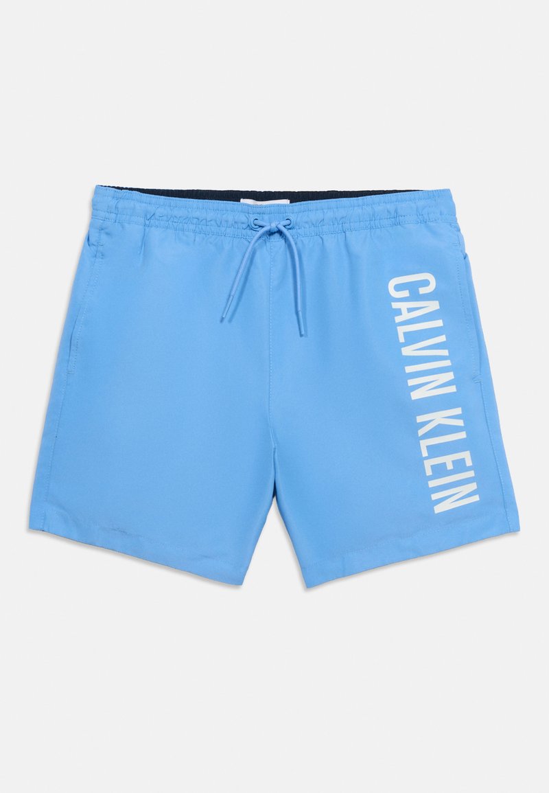 Helesinised ujumispüksid elastse vöökohaga ja paelaga, millel on paremal jalal valge vertikaalne "Calvin Klein" logo.