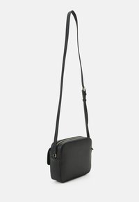 Borsa a tracolla di pelle nera con forma rettangolare, tracolla regolabile e dettaglio della zip in tonalità dorata sulla parte superiore. Texture liscia.
