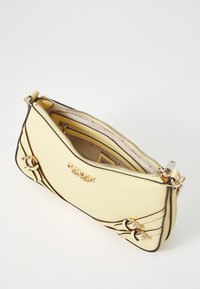 Yellow fabric clutch bag with gold-tone hardware, zipper closure, and embossed logo. Features curved seams and interior compartments.